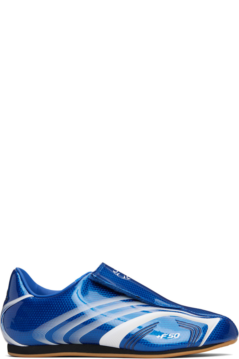 Low-top patent faux-leather sneakers.

· Stripes printed throughout
· Graphic printed at velcro closure
· Concealed elasticized gusset at vamp
· Padded collar
· Text stamp at outer side
· Logo printed at heel tab
· Jersey lining
· Foam rubber midsole
· Treaded rubber sole

Supplier color: Team royal blue/White