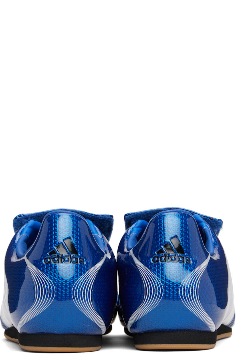 Low-top patent faux-leather sneakers.

· Stripes printed throughout
· Graphic printed at velcro closure
· Concealed elasticized gusset at vamp
· Padded collar
· Text stamp at outer side
· Logo printed at heel tab
· Jersey lining
· Foam rubber midsole
· Treaded rubber sole

Supplier color: Team royal blue/White