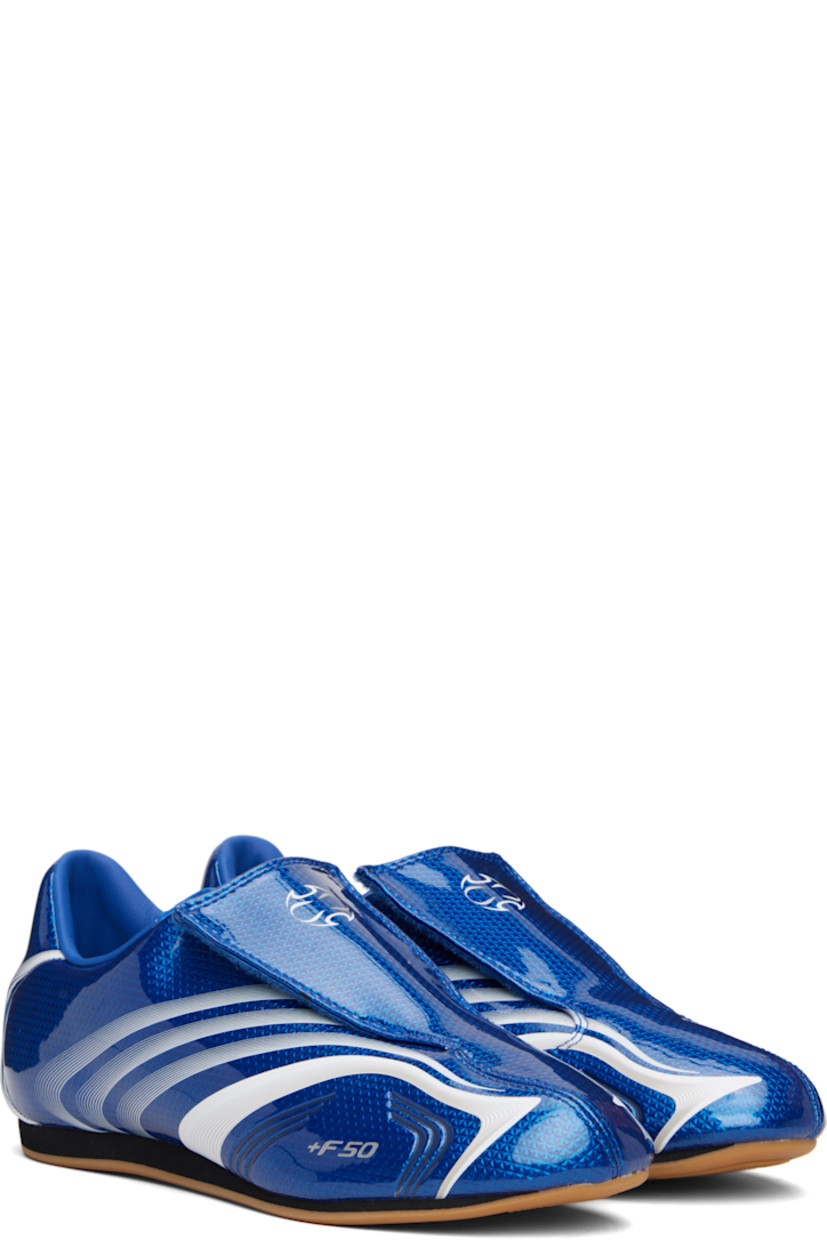 Low-top patent faux-leather sneakers.

· Stripes printed throughout
· Graphic printed at velcro closure
· Concealed elasticized gusset at vamp
· Padded collar
· Text stamp at outer side
· Logo printed at heel tab
· Jersey lining
· Foam rubber midsole
· Treaded rubber sole

Supplier color: Team royal blue/White
