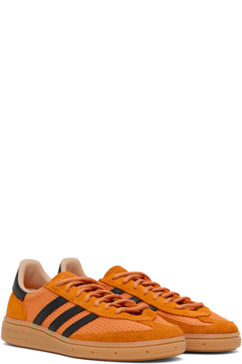 Low-top paneled mesh, suede, and buffed faux-leather sneakers.

· Lace-up closure
· Logo patch at tongue
· Padded collar
· Signature serrated stripes at sides
· Perforations at midsole 
· Treaded rubber sole 

Supplier color: Crew orange/Core black/Warm sandstone