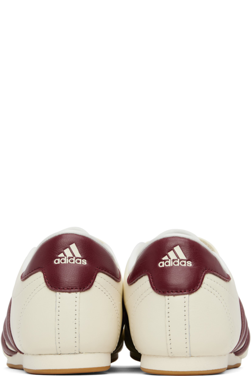 Low-top buffed leather sneakers.

· Quilted detailing at toe
· Logo embossed at vamp and heel tab
· Concealed elasticized gusset
· Padded tongue and collar
· Signature stripes and perforations at sides
· Buffed leather and mesh lining
· Treaded rubber sole

Supplier color: Off white/Noble maroon