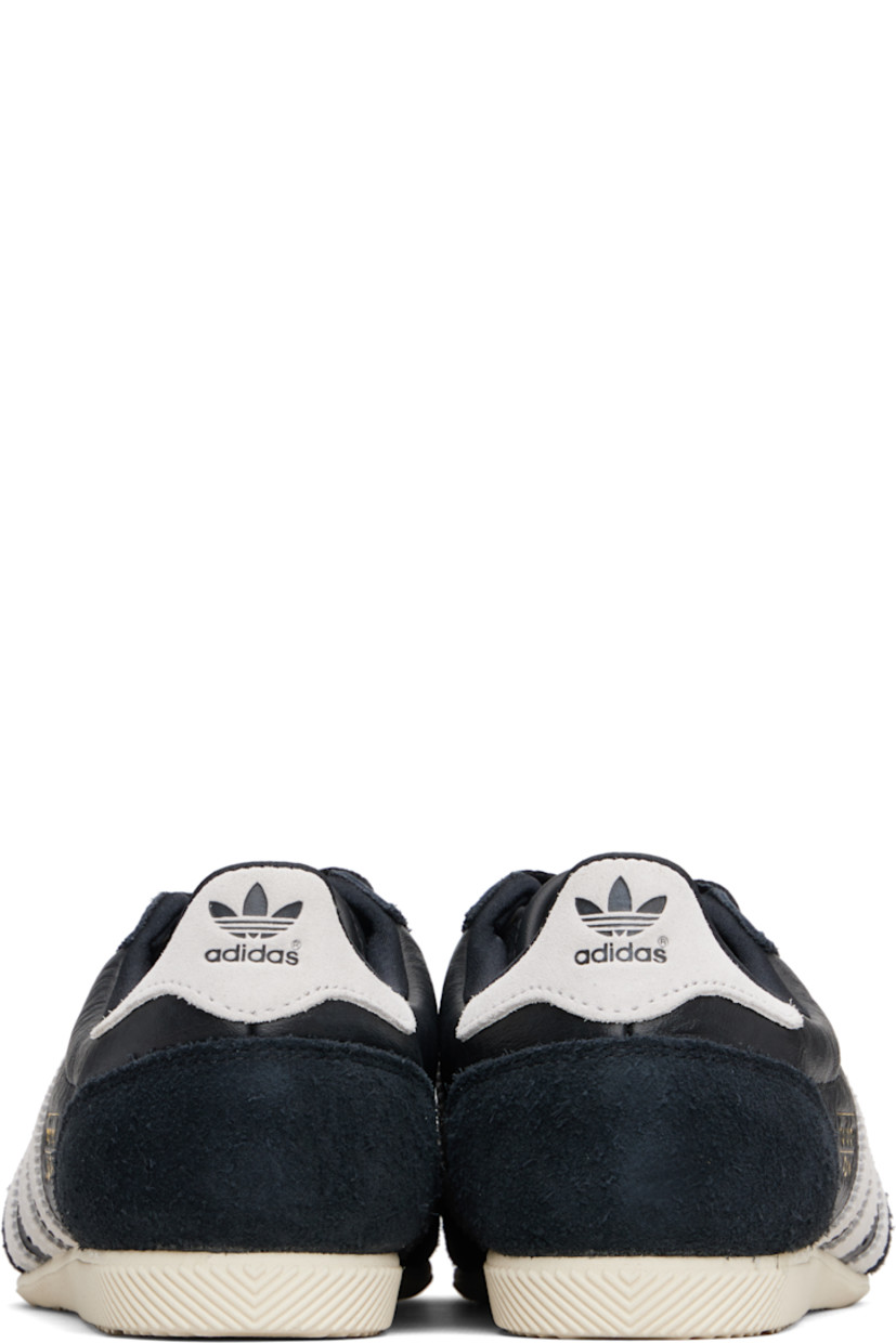 Low-top tumbled grained leather sneakers.

· Brushed suede trim throughout
· Perforations at toe and sides  
· Lace-up closure
· Logo patch at tongue 
· Padded collar 
· Signature stripes with serrated edges at sides
· Logo stamp at outer side
· Logo embossed at heel tab
· Treaded rubber sole 

Supplier color: Core black/Cloud white/Gold metallic