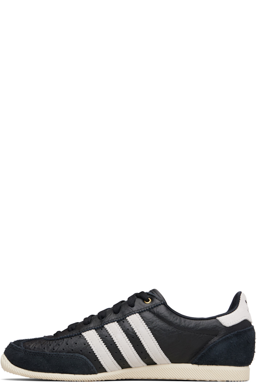 Low-top tumbled grained leather sneakers.

· Brushed suede trim throughout
· Perforations at toe and sides  
· Lace-up closure
· Logo patch at tongue 
· Padded collar 
· Signature stripes with serrated edges at sides
· Logo stamp at outer side
· Logo embossed at heel tab
· Treaded rubber sole 

Supplier color: Core black/Cloud white/Gold metallic