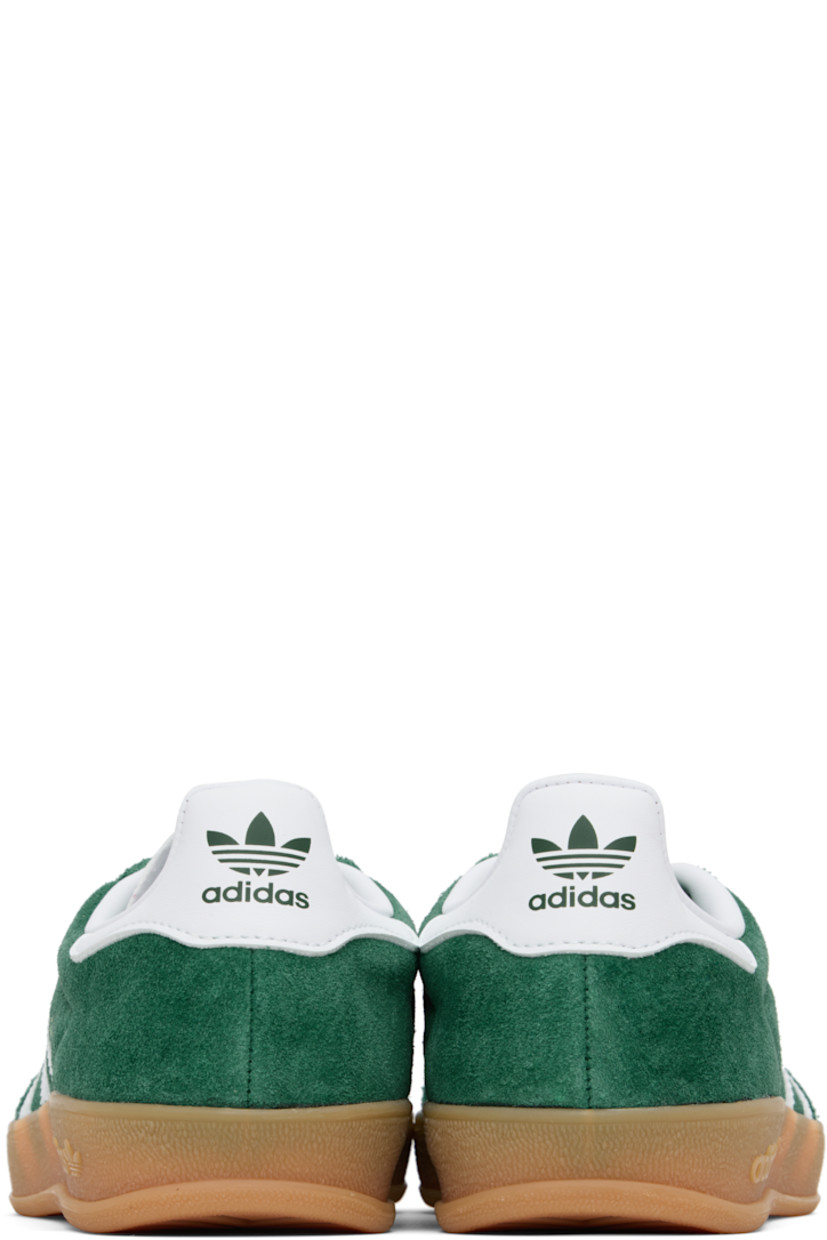 Low-top suede and buffed leather sneakers.

· Lace-up closure
· Logo printed at tongue
· Padded collar
· Text stamp at outer side
· Signature serrated stripes at sides
· Buffed leather lining
· Treaded rubber sole

Supplier color: Collegiate green/Cloud white/Gum