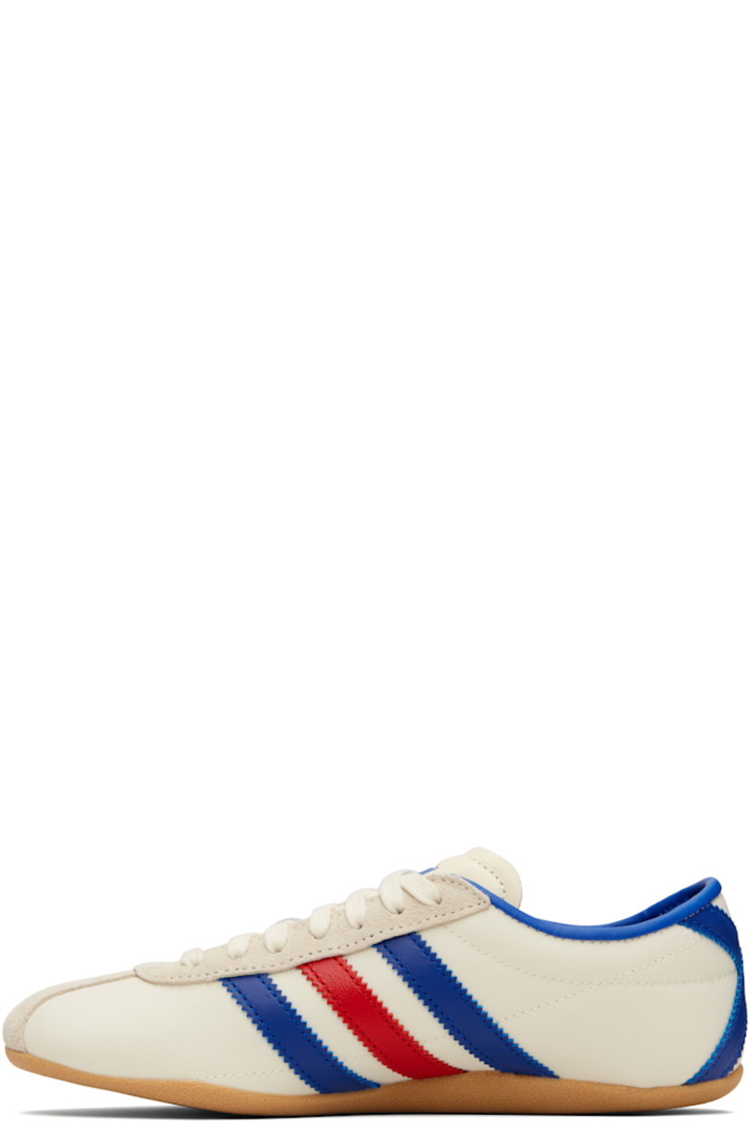 Low-top canvas, buffed leather, and suede sneakers.

· Lace-up closure
· Logo bonded at padded tongue
· Padded collar
· Signature serrated stripes at sides and heel
· Logo stamp at outer side
· Buffed faux-leather and mesh lining
· Textured rubber sole

Supplier color: Cream white/Royal blue/Gum