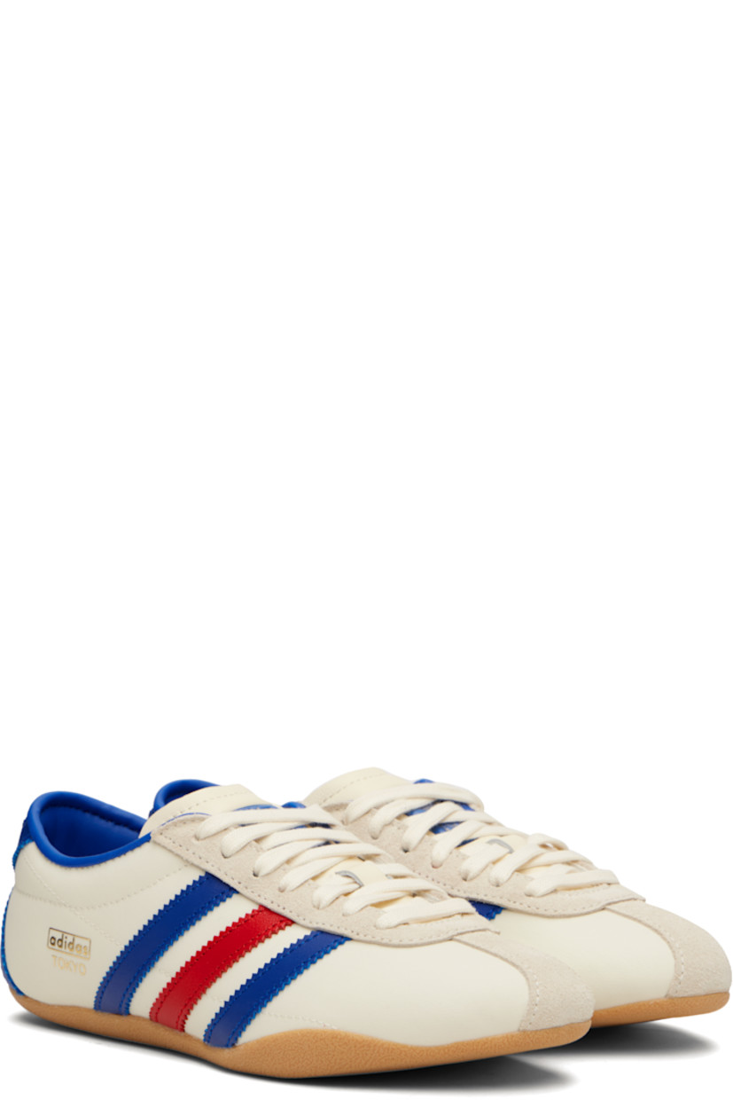 Low-top canvas, buffed leather, and suede sneakers.

· Lace-up closure
· Logo bonded at padded tongue
· Padded collar
· Signature serrated stripes at sides and heel
· Logo stamp at outer side
· Buffed faux-leather and mesh lining
· Textured rubber sole

Supplier color: Cream white/Royal blue/Gum