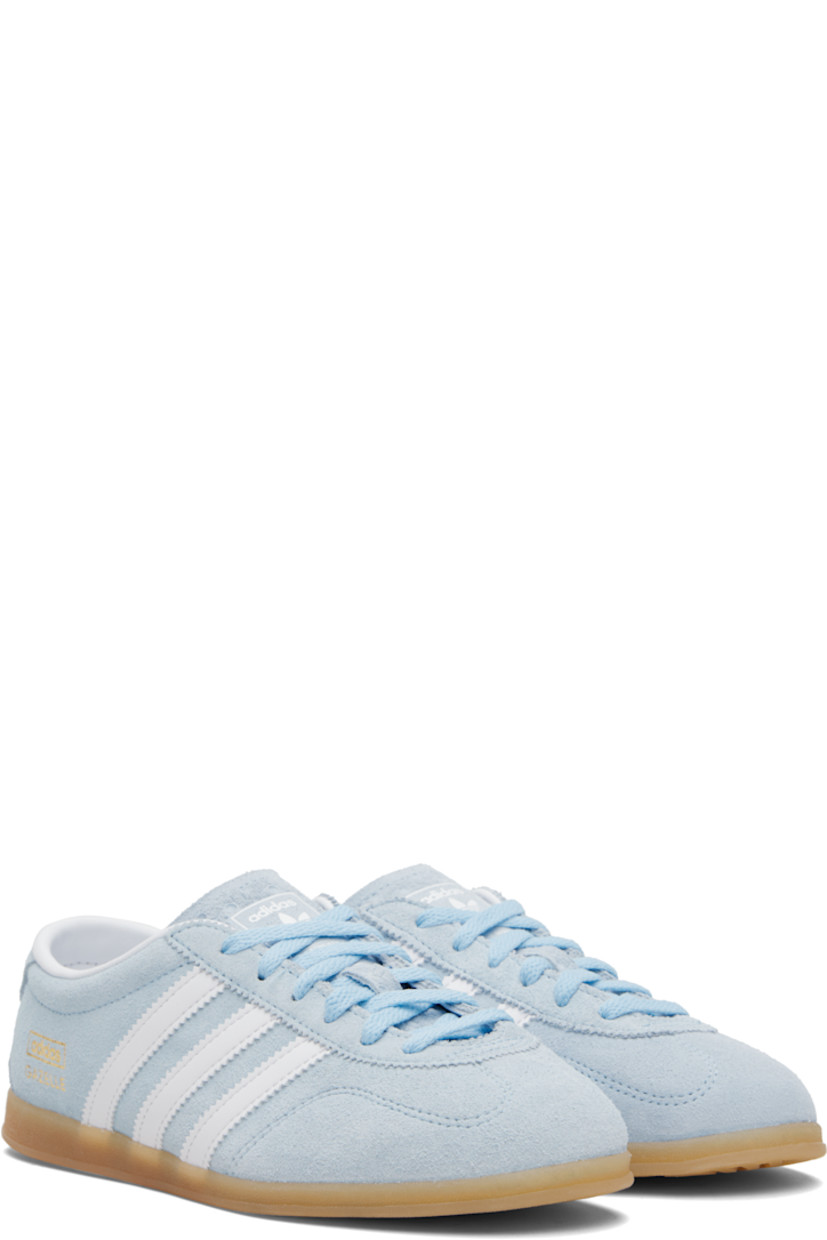 Low-top suede sneakers.

· Lace-up closure
· Logo printed at tongue
· Padded collar
· Signature serrated stripes at sides
· Logo and text stamp at outer side
· Jersey lining
· Treaded rubber sole

Supplier color: Clear sky/Cloud white/Gum