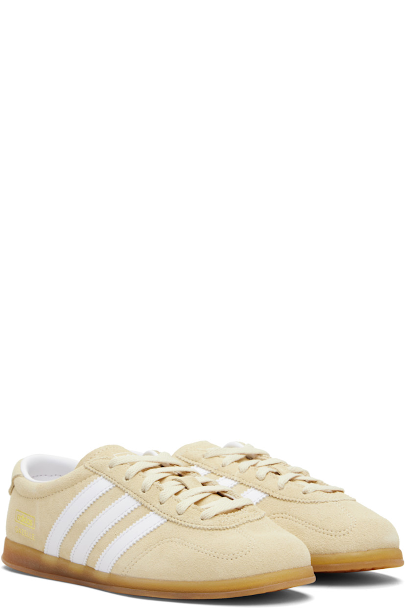 Low-top suede sneakers.

· Lace-up closure
· Logo printed at tongue
· Padded collar
· Signature serrated stripes at sides
· Logo and text stamp at outer side
· Jersey lining
· Treaded rubber sole

Supplier color: Sand strata/Cloud white/Gum