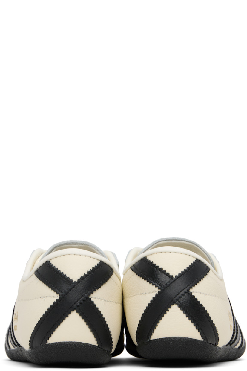 Low-top canvas, buffed leather, and suede sneakers.

· Lace-up closure
· Logo bonded at padded tongue
· Padded collar
· Signature serrated stripes at sides and heel
· Logo stamp at outer side
· Buffed faux-leather and mesh lining
· Crêpe-rubber sole

Supplier color: Off white/Core black/Gold metallic