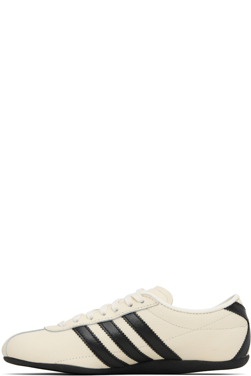 Low-top canvas, buffed leather, and suede sneakers.

· Lace-up closure
· Logo bonded at padded tongue
· Padded collar
· Signature serrated stripes at sides and heel
· Logo stamp at outer side
· Buffed faux-leather and mesh lining
· Crêpe-rubber sole

Supplier color: Off white/Core black/Gold metallic