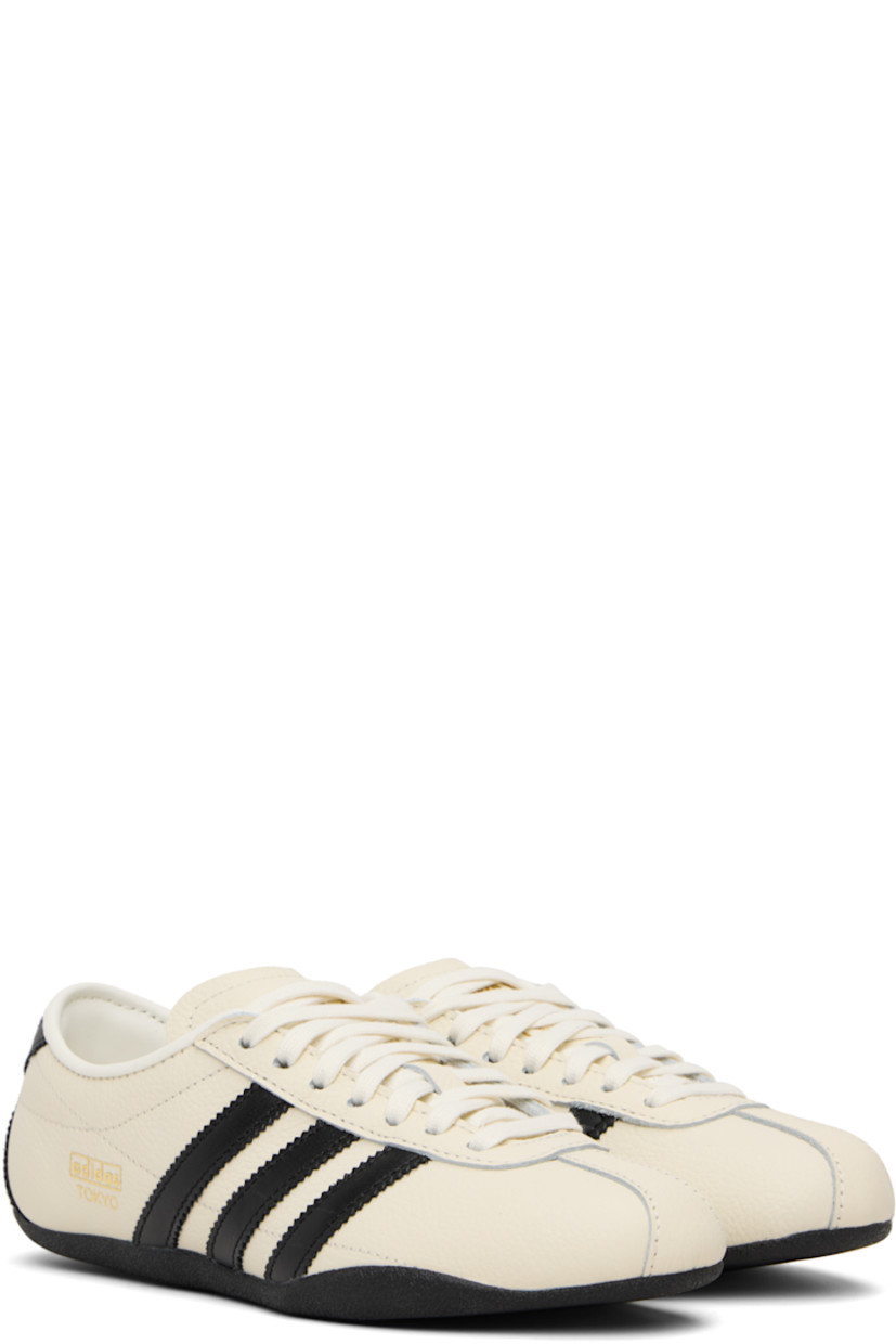 Low-top canvas, buffed leather, and suede sneakers.

· Lace-up closure
· Logo bonded at padded tongue
· Padded collar
· Signature serrated stripes at sides and heel
· Logo stamp at outer side
· Buffed faux-leather and mesh lining
· Crêpe-rubber sole

Supplier color: Off white/Core black/Gold metallic