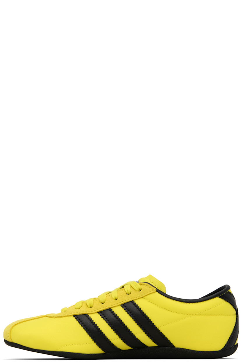 Low-top canvas, buffed leather, and suede sneakers.

· Lace-up closure
· Logo bonded at padded tongue
· Padded collar
· Signature serrated stripes at sides and heel
· Logo stamp at outer side
· Buffed faux-leather and mesh lining
· Crêpe-rubber sole

Supplier color: Pure sulfur/Dark brown/Gold metallic