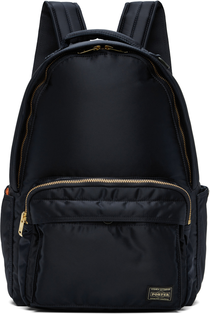Nylon twill backpack in navy.

· Padded carry handle
· Adjustable padded shoulder straps
· Bellows pocket at zip compartment
· Logo patch at face
· Patch pocket at sides
· Padded back face
· Two-way zip closure
· Patch pocket at interior
· Taffeta lining
· Logo-engraved gold-tone hardware
· H15" x W11.5" x D5.25" / 12 L

Supplier color: Iron blue