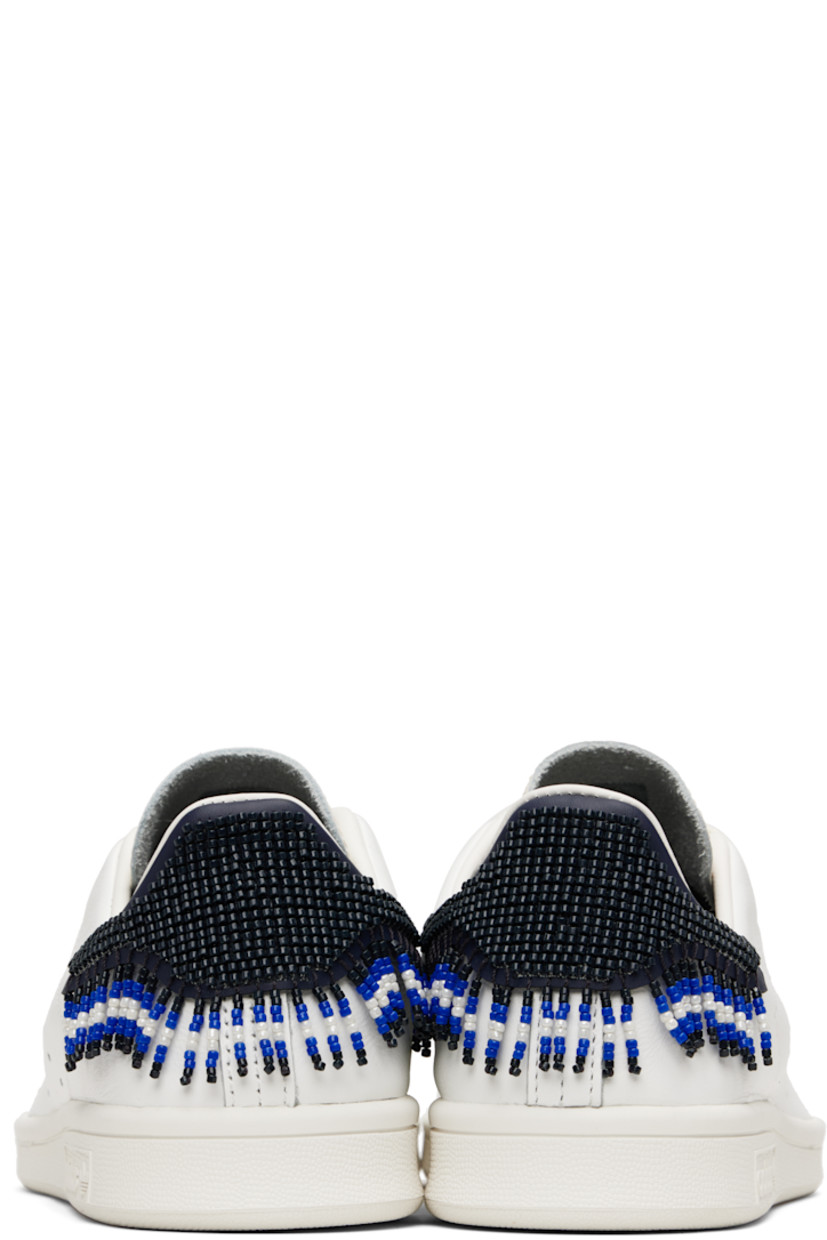 Low-top buffed leather sneakers.

· Text embroidered at vamp
· Lace-up closure
· Logo embossed at tongue
· Padded collar
· Perforated stripes at sides
· Beaded detailing at heel tab
· Treaded rubber sole

Part of the adidas Originals by Edison Chen collaboration.

Supplier color: Core white/Night navy/Core white