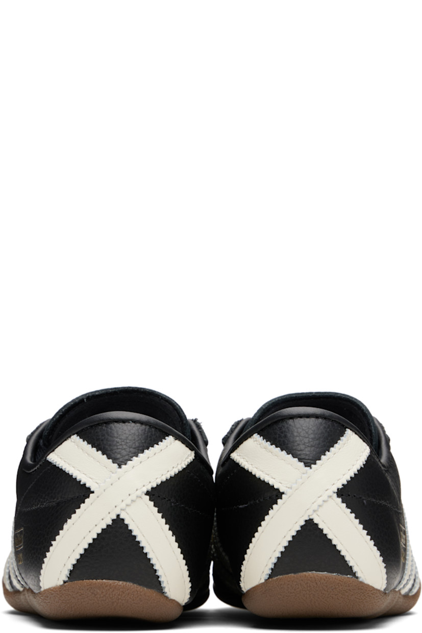 Low-top grained leather sneakers.

· Lace-up closure
· Logo stamp at tongue and outer side
· Padded collar
· Signature serrated stripes at sides and heel
· Mesh lining
· Crêpe-rubber sole

Supplier color: Black/Off white/Gold