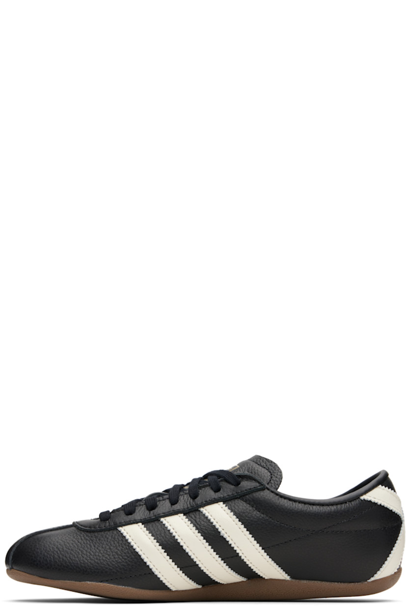 Low-top grained leather sneakers.

· Lace-up closure
· Logo stamp at tongue and outer side
· Padded collar
· Signature serrated stripes at sides and heel
· Mesh lining
· Crêpe-rubber sole

Supplier color: Black/Off white/Gold
