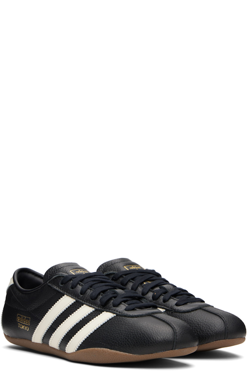 Low-top grained leather sneakers.

· Lace-up closure
· Logo stamp at tongue and outer side
· Padded collar
· Signature serrated stripes at sides and heel
· Mesh lining
· Crêpe-rubber sole

Supplier color: Black/Off white/Gold