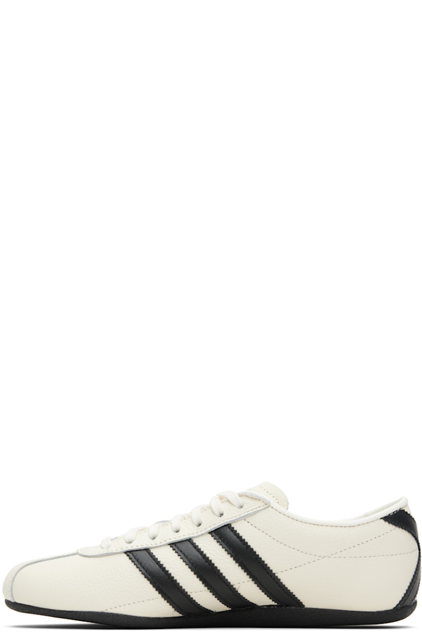 Low-top grained leather sneakers.

· Lace-up closure
· Logo stamp at tongue and outer side
· Padded collar
· Signature serrated stripes at sides and heel
· Mesh lining
· Crêpe-rubber sole

Supplier color: Off white/Core black/Gold metallic