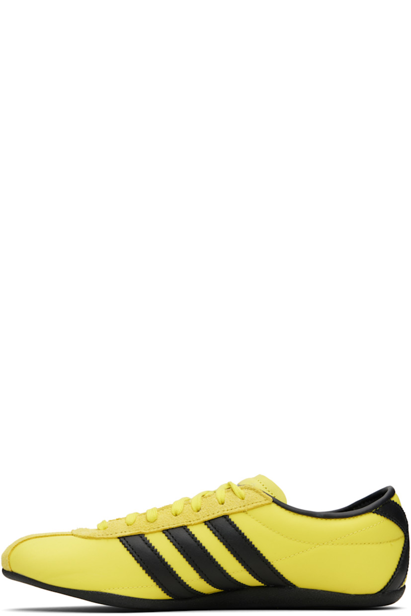 Low-top canvas, buffed leather, and suede sneakers.

· Lace-up closure
· Logo bonded at padded tongue
· Padded collar
· Signature serrated stripes at sides and heel
· Logo stamp at outer side
· Buffed faux-leather and mesh lining
· Textured rubber sole

Supplier color: Pure sulfur/Dark brown/Gold metallic