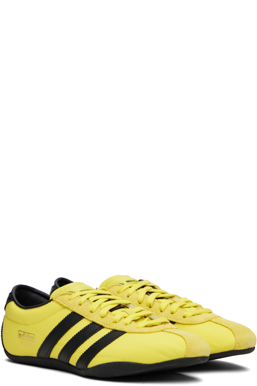 Low-top canvas, buffed leather, and suede sneakers.

· Lace-up closure
· Logo bonded at padded tongue
· Padded collar
· Signature serrated stripes at sides and heel
· Logo stamp at outer side
· Buffed faux-leather and mesh lining
· Textured rubber sole

Supplier color: Pure sulfur/Dark brown/Gold metallic