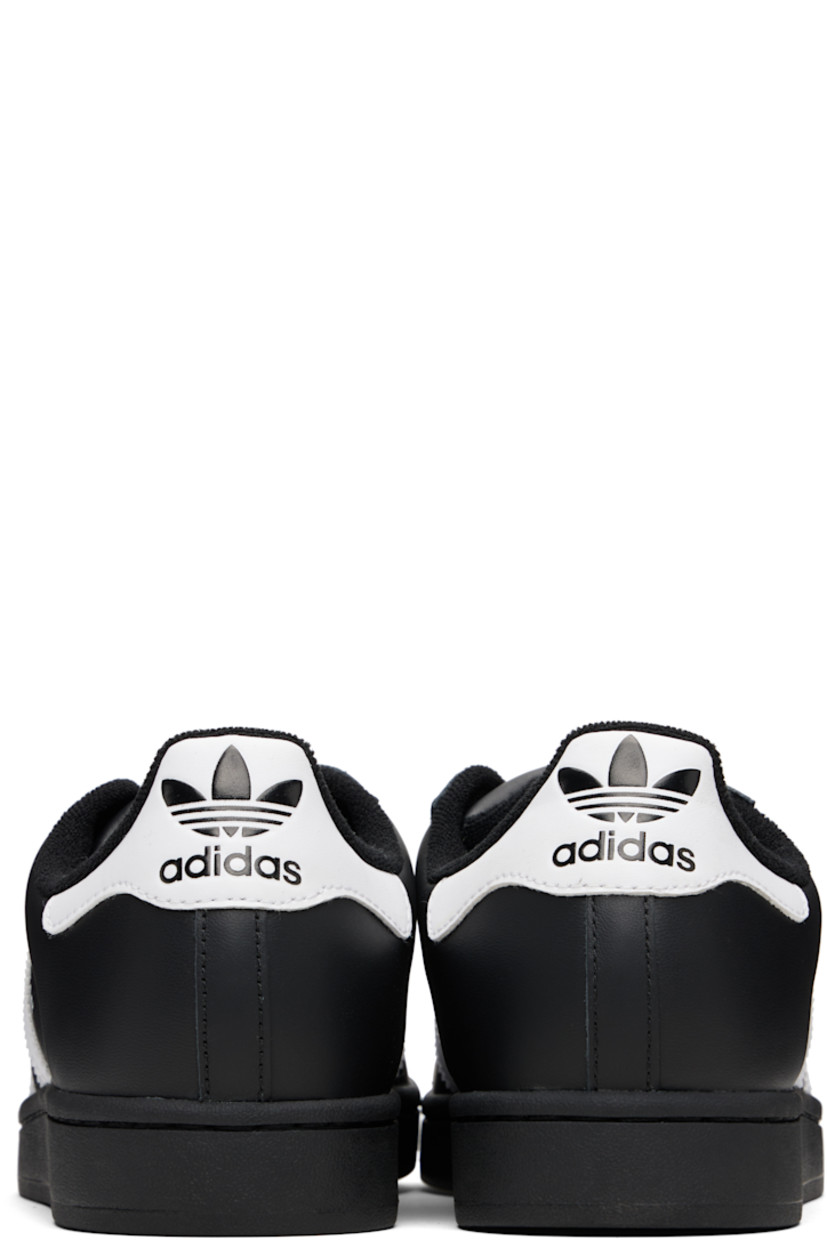 Low-top buffed leather sneakers.

· Textured rubber cap toe
· Lace-up closure
· Logo embossed at tongue and heel tab
· Padded tongue and collar
· Text printed at outer side
· Perforations and signature serrated stripes at sides
· Terrycloth lining
· Treaded rubber sole

Supplier color: Core black/Cloud white/Core black