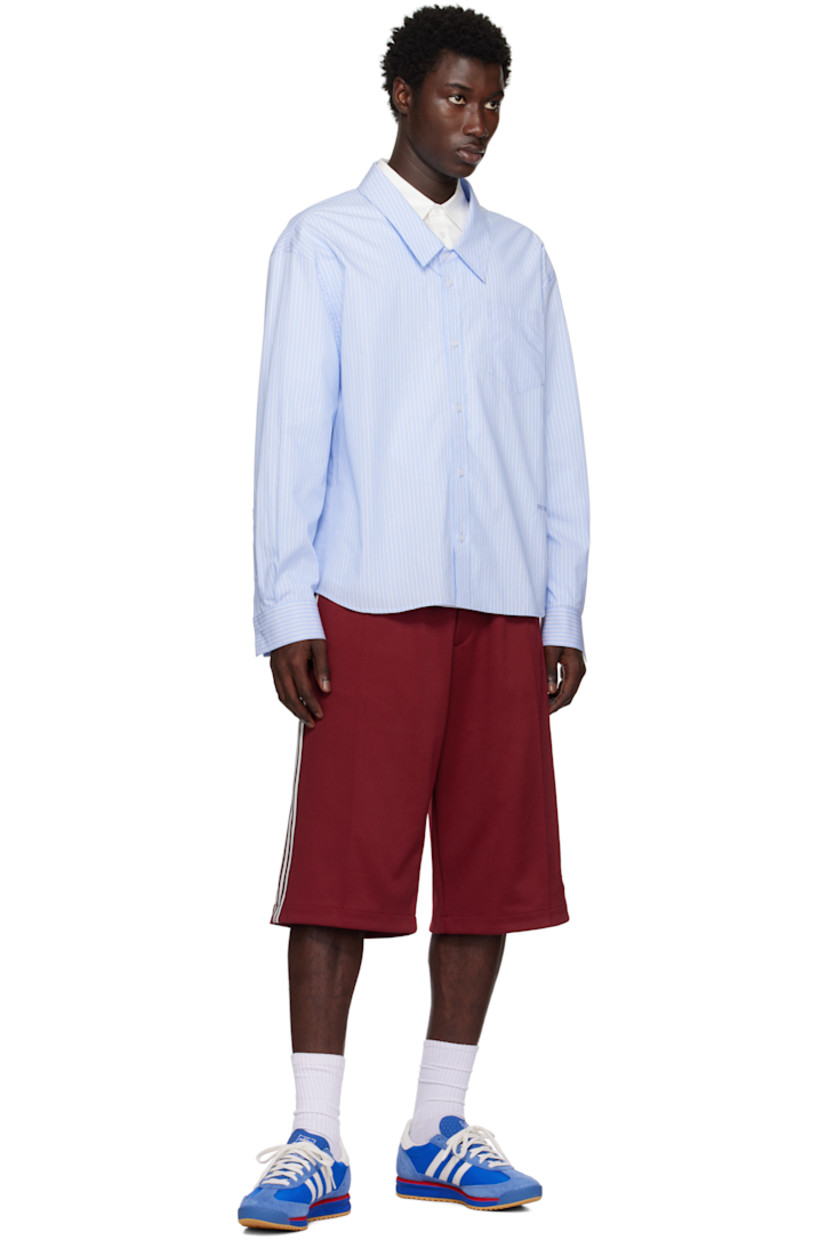 Low-top suede and canvas sneakers.

· Lace-up closure
· Logo printed at textured tongue
· Padded collar
· Signature serrated stripes at sides
· Logo and text stamp at outer side
· Logo printed at heel tab
· Mesh lining
· Logo embossed at foam rubber midsole
· Treaded rubber sole

Supplier color: Blue/Core white/Better scarlet