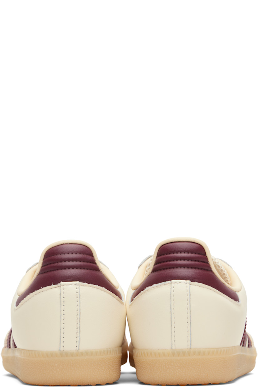 Low-top buffed leather sneakers.

· Suede trim at toe
· Lace-up closure
· Logo patch at padded tongue
· Padded collar
· Text stamp at outer side
· Signature serrated stripes at sides
· Quilted heel tab
· Mesh lining
· Treaded rubber sole

Supplier color: Wonder white/Shadow red/Gum