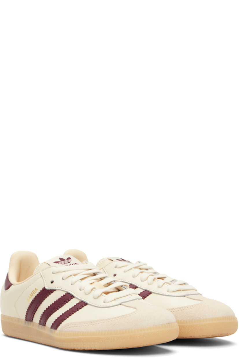 Low-top buffed leather sneakers.

· Suede trim at toe
· Lace-up closure
· Logo patch at padded tongue
· Padded collar
· Text stamp at outer side
· Signature serrated stripes at sides
· Quilted heel tab
· Mesh lining
· Treaded rubber sole

Supplier color: Wonder white/Shadow red/Gum