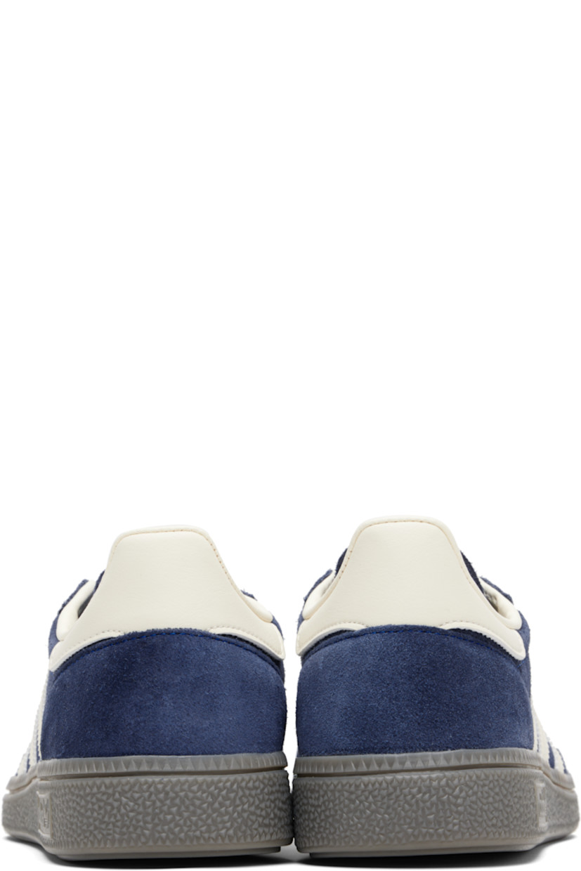 Low-top suede sneakers.

· Lace-up closure
· Logo patch at tongue
· Padded collar
· Text and logo stamp at outer side
· Signature serrated stripes at sides
· Mesh lining
· Treaded rubber sole

Supplier color: Night indigo/Cream white/Cloud white
