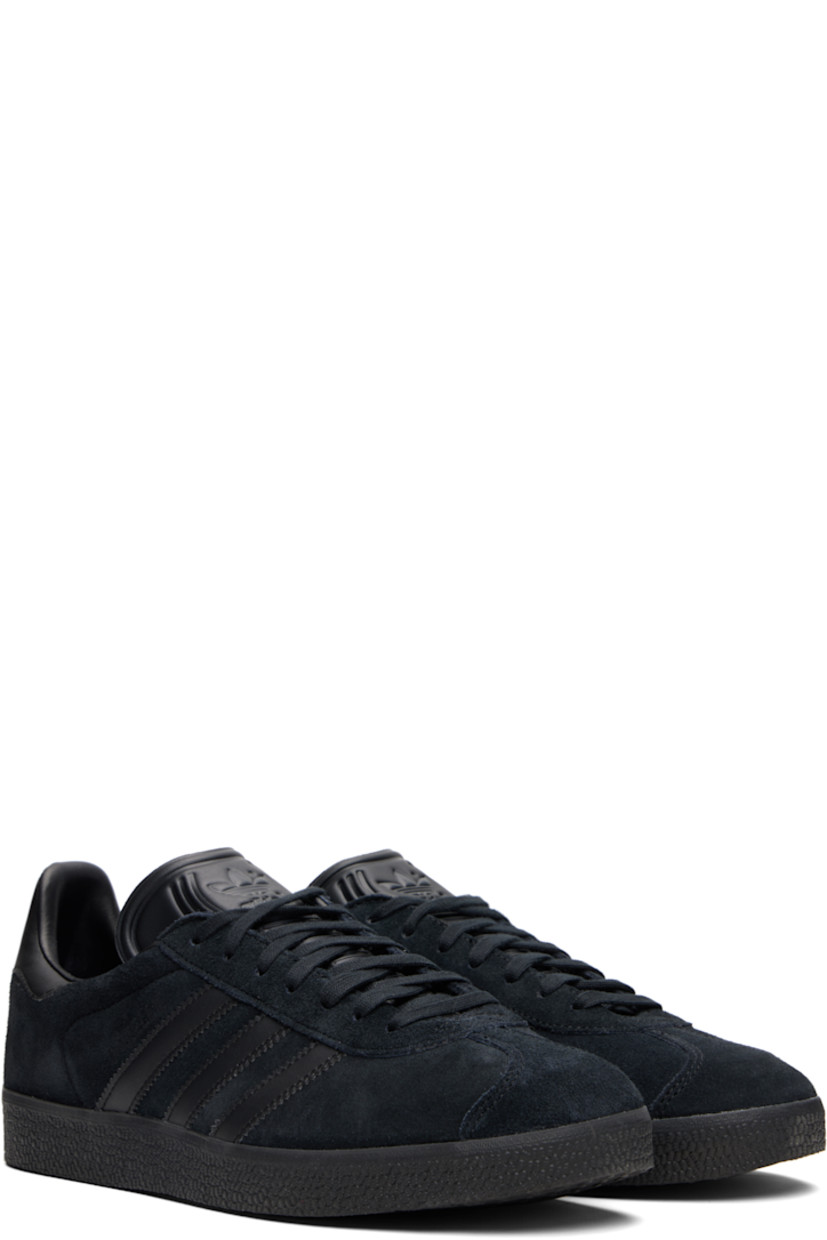 Low-top nubuck sneakers.

· Lace-up closure
· Logo embossed at tongue
· Padded collar
· Text printed at outer side
· Signature serrated stripes at sides
· Logo printed at heel tab
· Mesh lining
· Treaded rubber sole

Supplier color: Core black/Core black/Core black