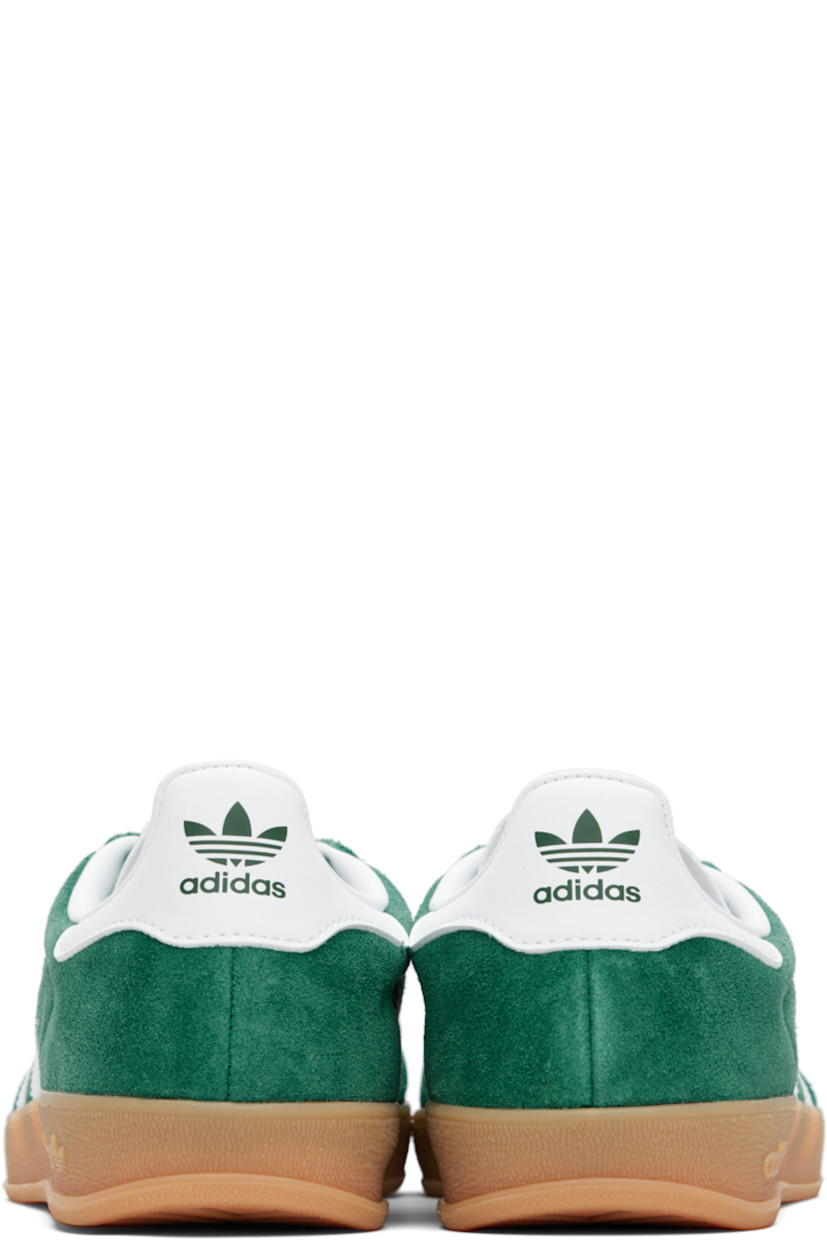 Low-top suede sneakers.

· Lace-up closure
· Logo printed at textured tongue
· Padded collar
· Text stamp at outer side
· Signature serrated stripes at sides
· Logo printed at heel tab
· Jersey lining
· Treaded rubber sole
· Includes alternate laces

Supplier color: Collegiate green/Cloud white/Gum