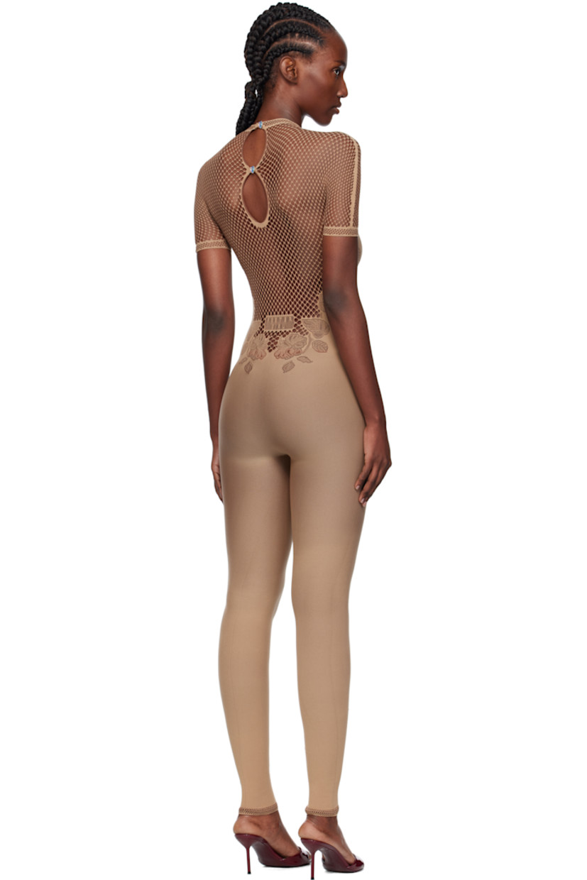 Stretch fishnet jumpsuit. 

· Semi-sheer
· Pointelle-knit floral pattern throughout
· Mock neck
· Button closure with crystal at back collar
· Jacquard logo at back

Supplier color: Beige