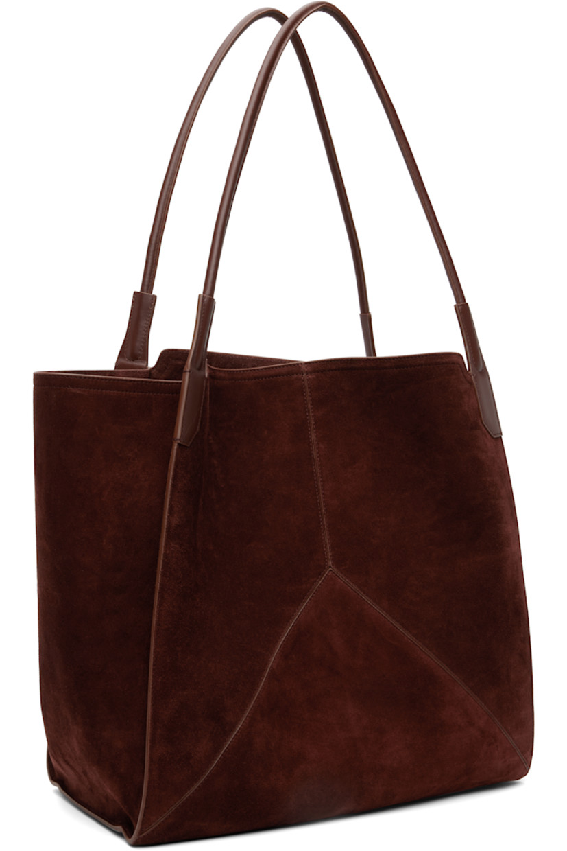 Calfskin suede tote.

· Twin rolled shoulder straps
· Logo stamp at face
· Bumper pads at base
· Patch pocket at interior 
· H15.5" x W15" x D7"

Supplier color: Dark brown