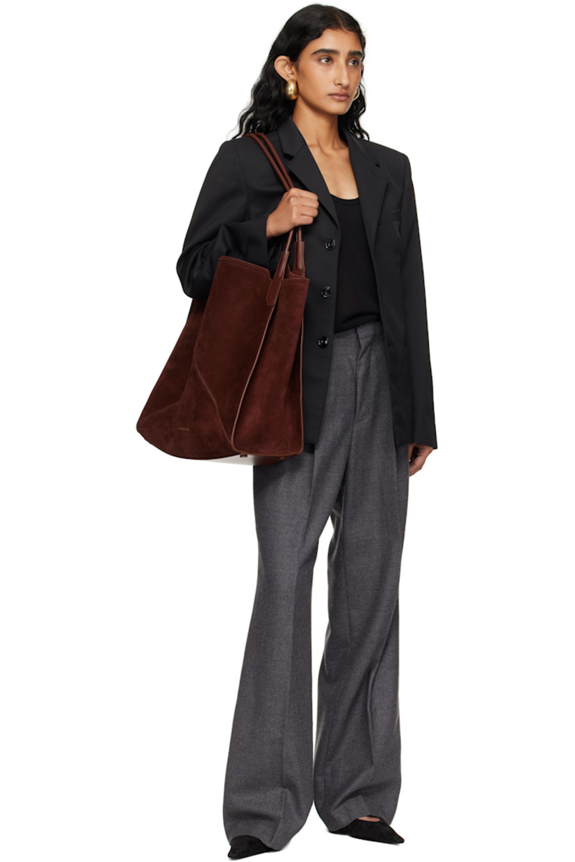 Calfskin suede tote.

· Twin rolled shoulder straps
· Logo stamp at face
· Bumper pads at base
· Patch pocket at interior 
· H15.5" x W15" x D7"

Supplier color: Dark brown