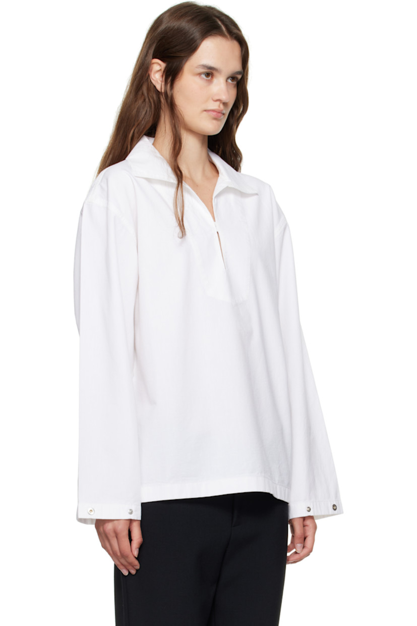 Non-stretch denim blouse.

· Open spread collar
· Button tab at chest
· Dropped shoulders
· Press-stud tab at cuffs
· Contrast stitching in brown at back yoke 

Supplier color: Washed white