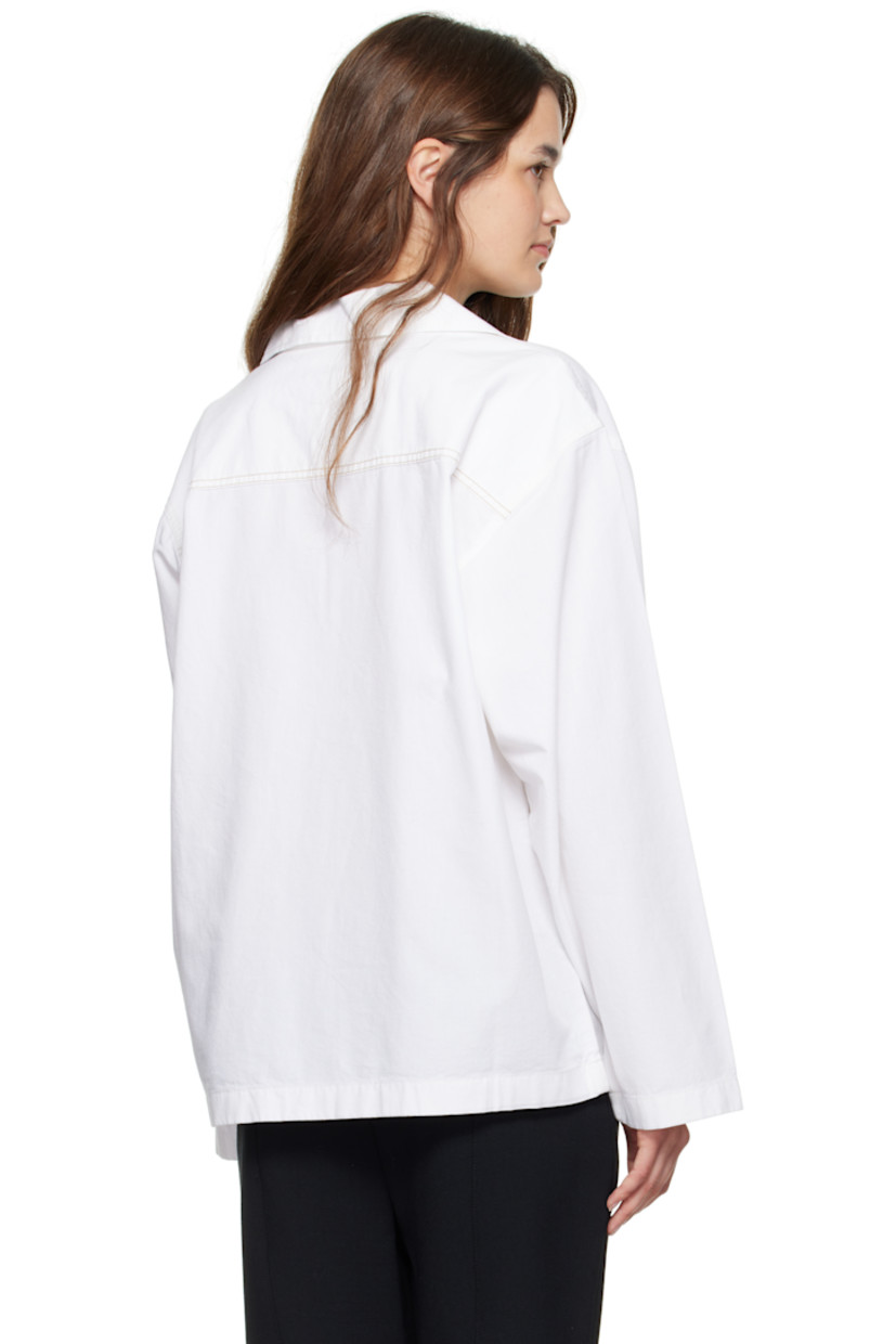 Non-stretch denim blouse.

· Open spread collar
· Button tab at chest
· Dropped shoulders
· Press-stud tab at cuffs
· Contrast stitching in brown at back yoke 

Supplier color: Washed white