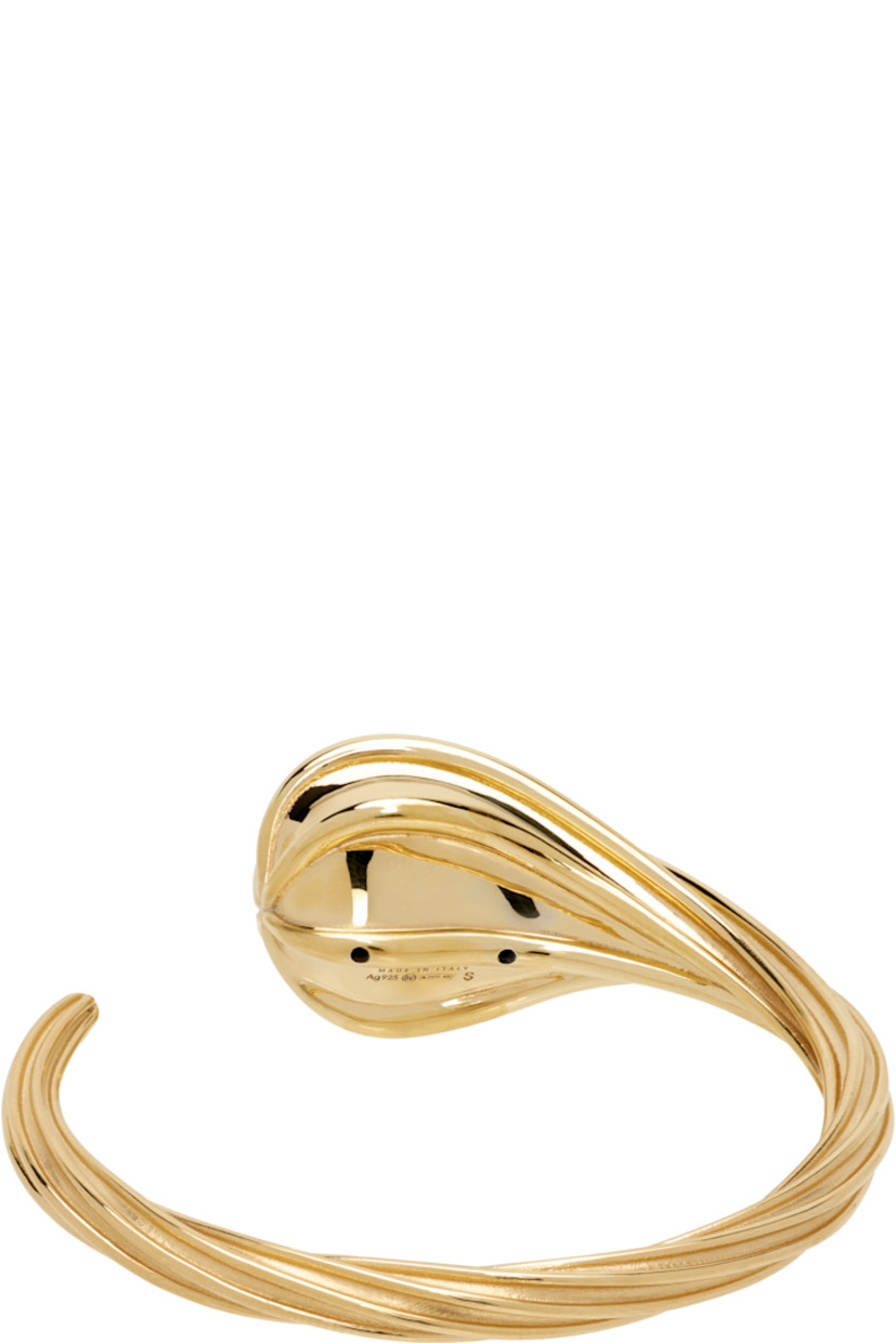 Sculptural open cuff bracelet in 18k yellow gold-plated sterling silver. Fluted detailing throughout.

Supplier color: Yellow gold