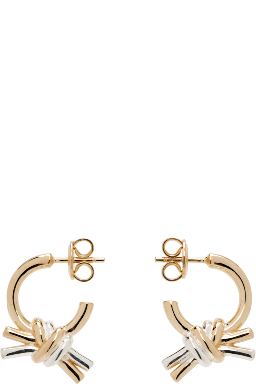 Pair of drop earrings in 18k yellow gold-plated sterling silver.

· Knot with sterling silver detailing
· Post-stud fastening
· H0.75" x W0.5"

Supplier color: Yellow gold