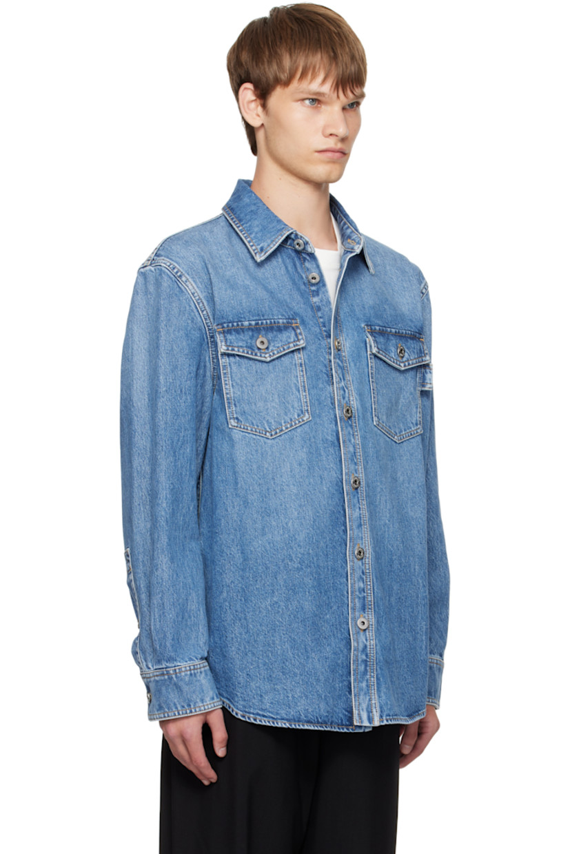 Non-stretch denim shirt.

· Fading throughout
· Spread collar
· Button closure
· Flap pockets at chest
· Shirttail hem
· Buttoned barrel cuffs
· Contrast stitching in tan

Supplier color: Blue