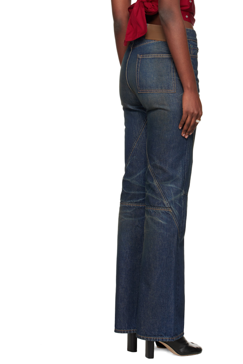 Non-stretch denim jeans.

· Fading, whiskering, and darts throughout
· Flares at knee
· Mid-rise
· Belt loops
· Five-pocket styling
· Zip fly
· Contrast stitching in tan

Supplier color: Sand tint
