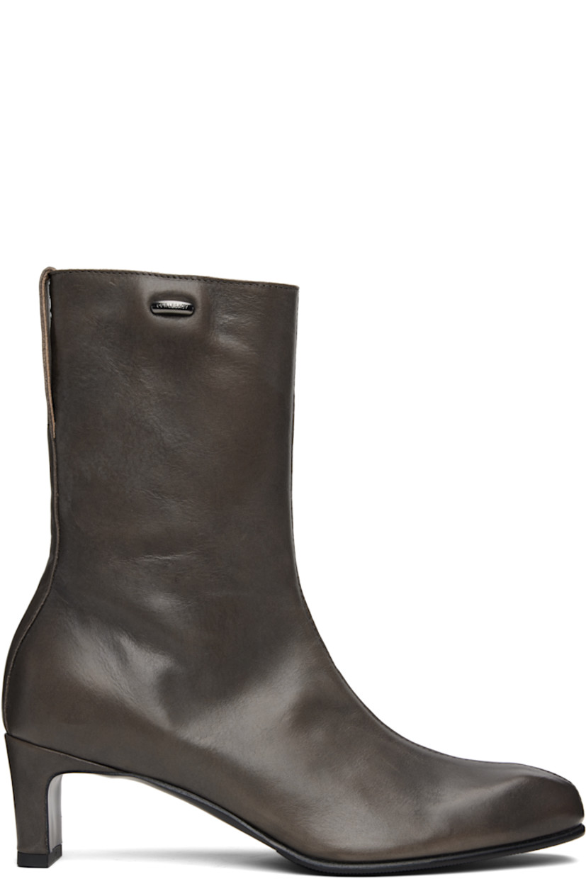 Ankle-high vegetable-tanned buffed leather boots.

· Almond toe
· Logo hardware at outer side
· Zip closure at inner side
· Pull-loop at heel collar
· Covered block heel with rubber injection
· Leather sole with rubber injection
· Heel: H2.25"

Supplier color: Phantom tensile cattle hide