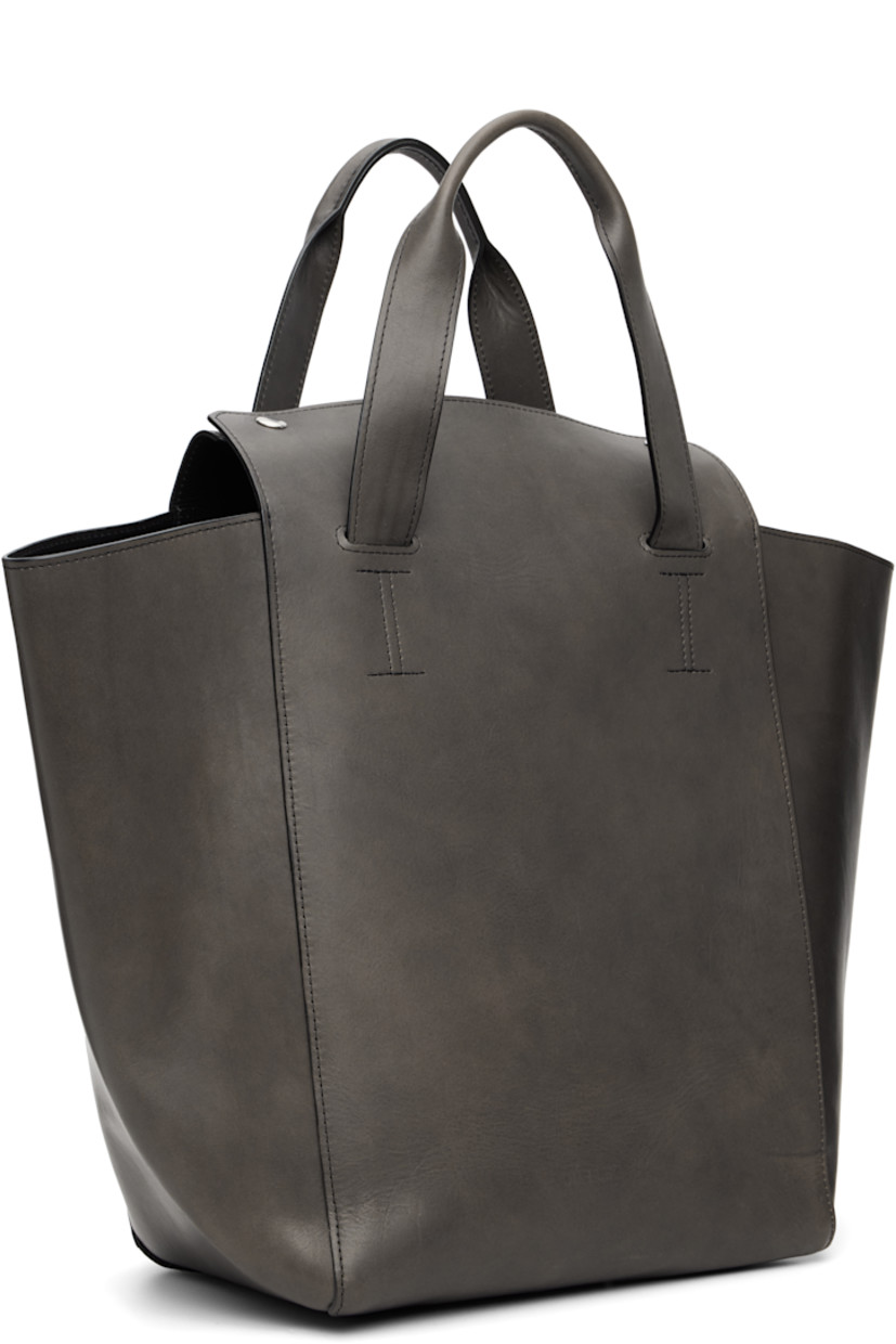 Buffed calfskin tote.

· Fixed carry handles
· Logo embossed at face
· Press-stud closure
· Zip and patch pocket at interior
· H13" x W20" x D7.5"

Supplier color: Phantom tensile