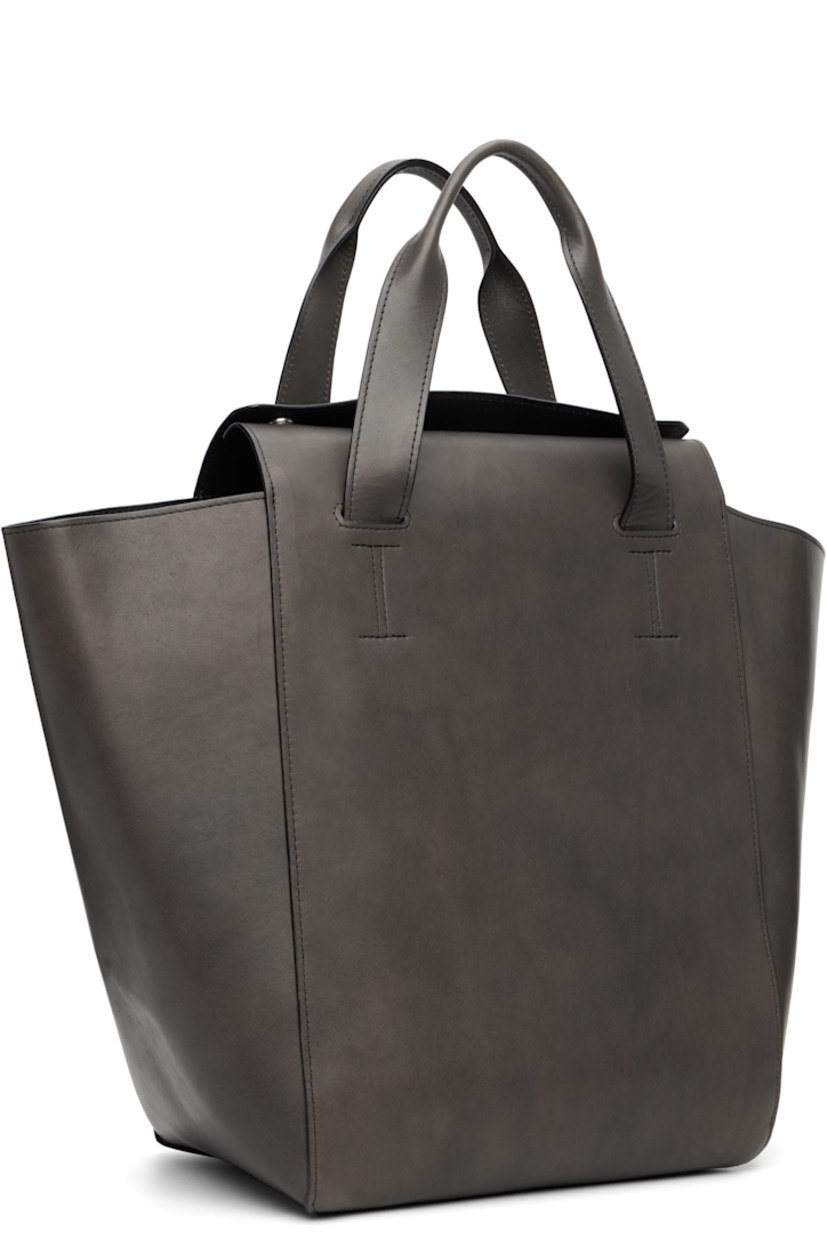 Buffed calfskin tote.

· Fixed carry handles
· Logo embossed at face
· Press-stud closure
· Zip and patch pocket at interior
· H13" x W20" x D7.5"

Supplier color: Phantom tensile
