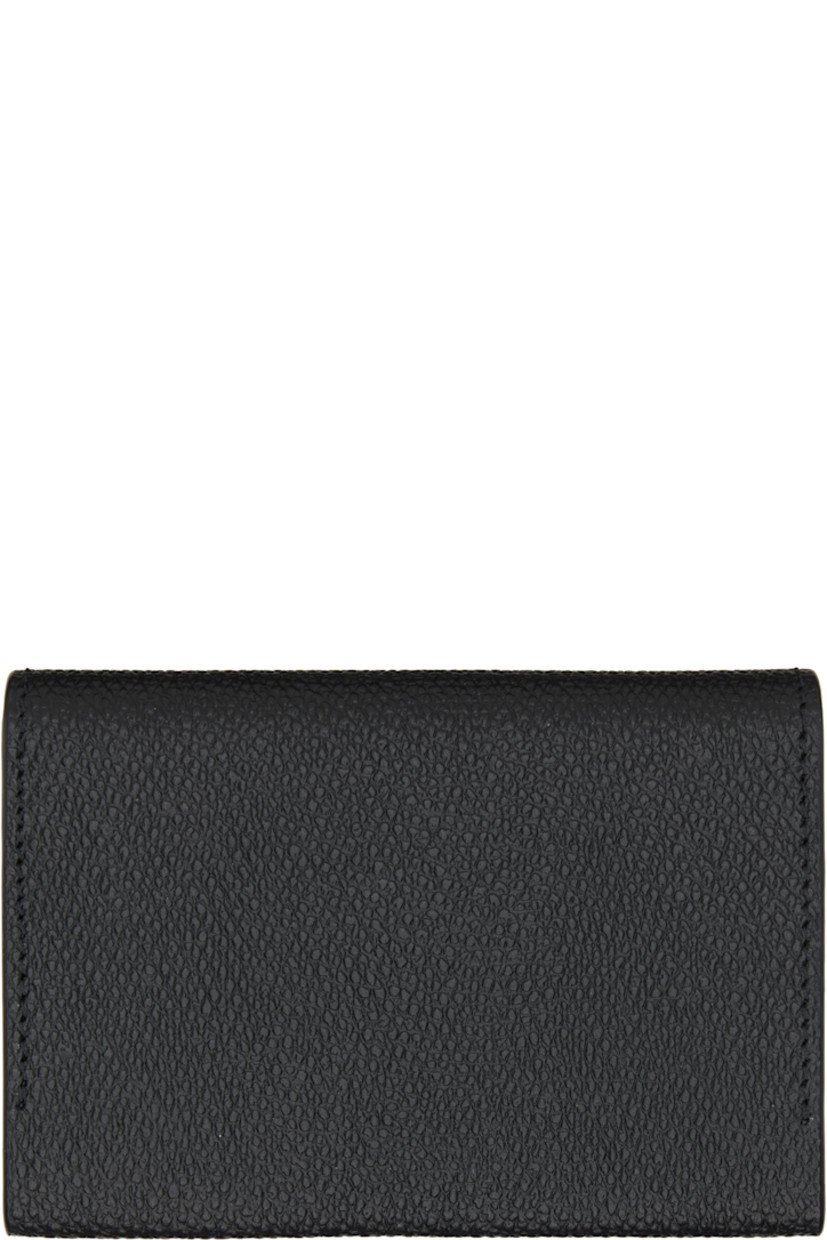 Pebble-grained calfskin bifold card holder. 

· Logo hardware at face
· Press-stud closure
· Three card slots and two patch pockets at interior 
· Silver-tone hardware
· H3" x W4.25" x D0.75"

Supplier color: Nero