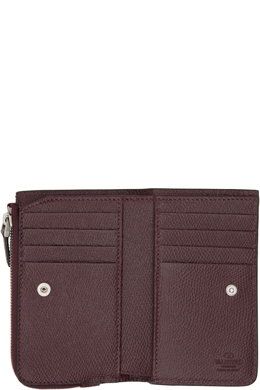 Pebble-grained calfskin wallet.

· Logo hardware and zip coin compartment at face
· Press-stud closure
· Eight card slots at interior 
· Two patch pockets and one note slot
· Canvas lining 
· Silver-tone hardware 
· H3.25" x W5" x D0.75"

Supplier color: Rosewood