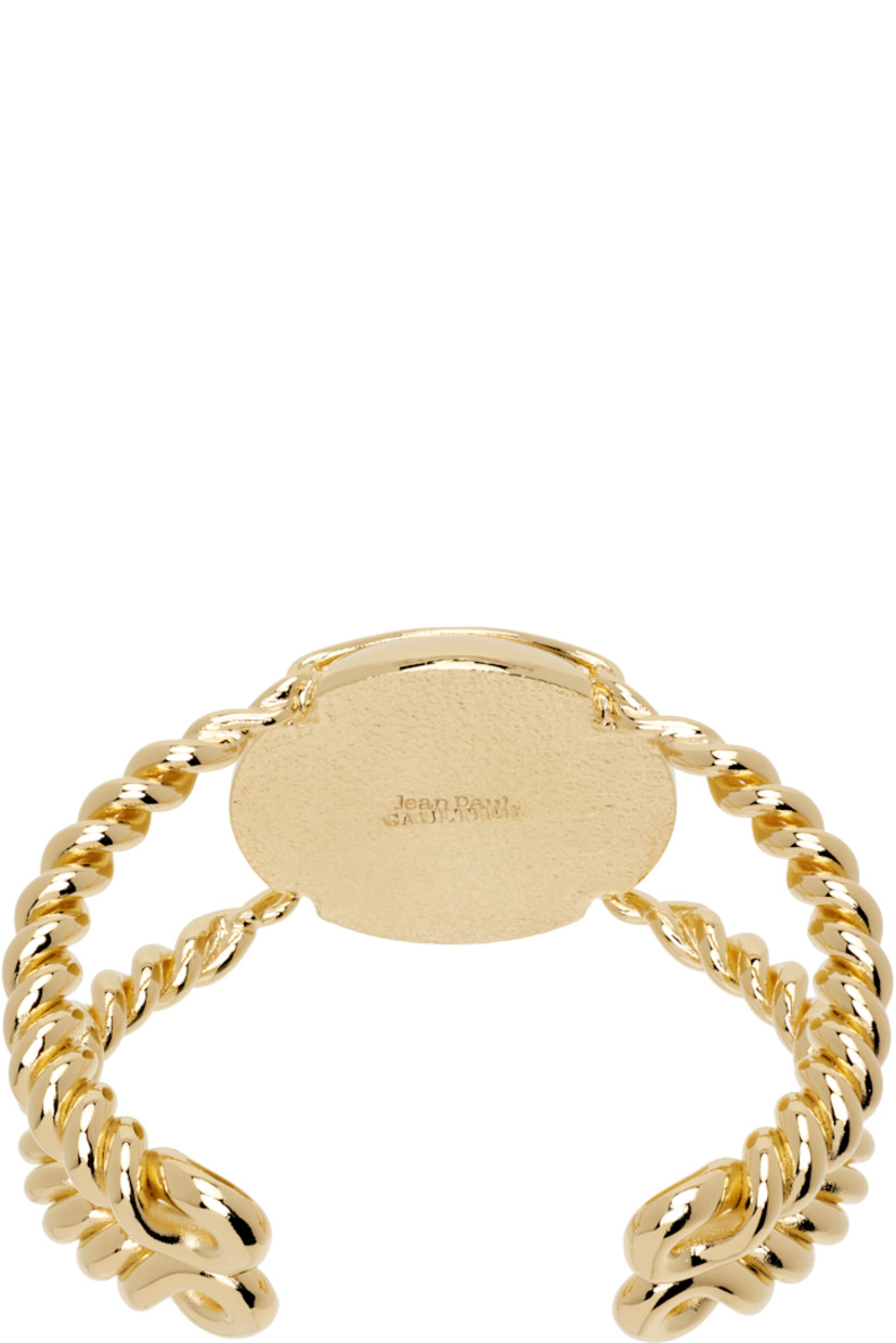 Sculptural open cuff bracelet in gold-tone brass. 

· Twisted detailing throughout
· Logo engraved at face
· D2.5"

Supplier color: Gold