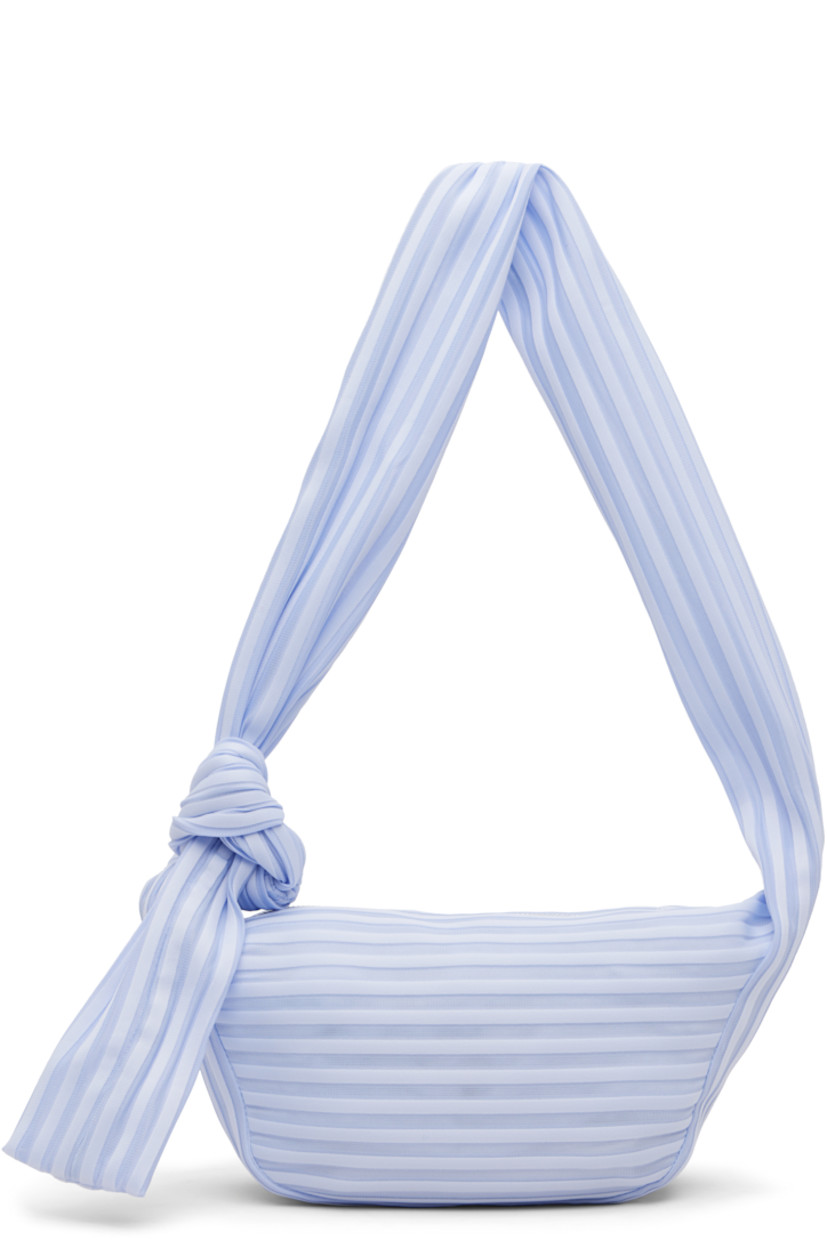 Technical knit shoulder bag.

· Semi-sheer ribbed stripes throughout
· Adjustable self-tie crossbody strap
· Zip closure
· Phone compartment at interior
· Unlined
· H6" x W11" x D3.5"

Supplier color: Nigella Blue