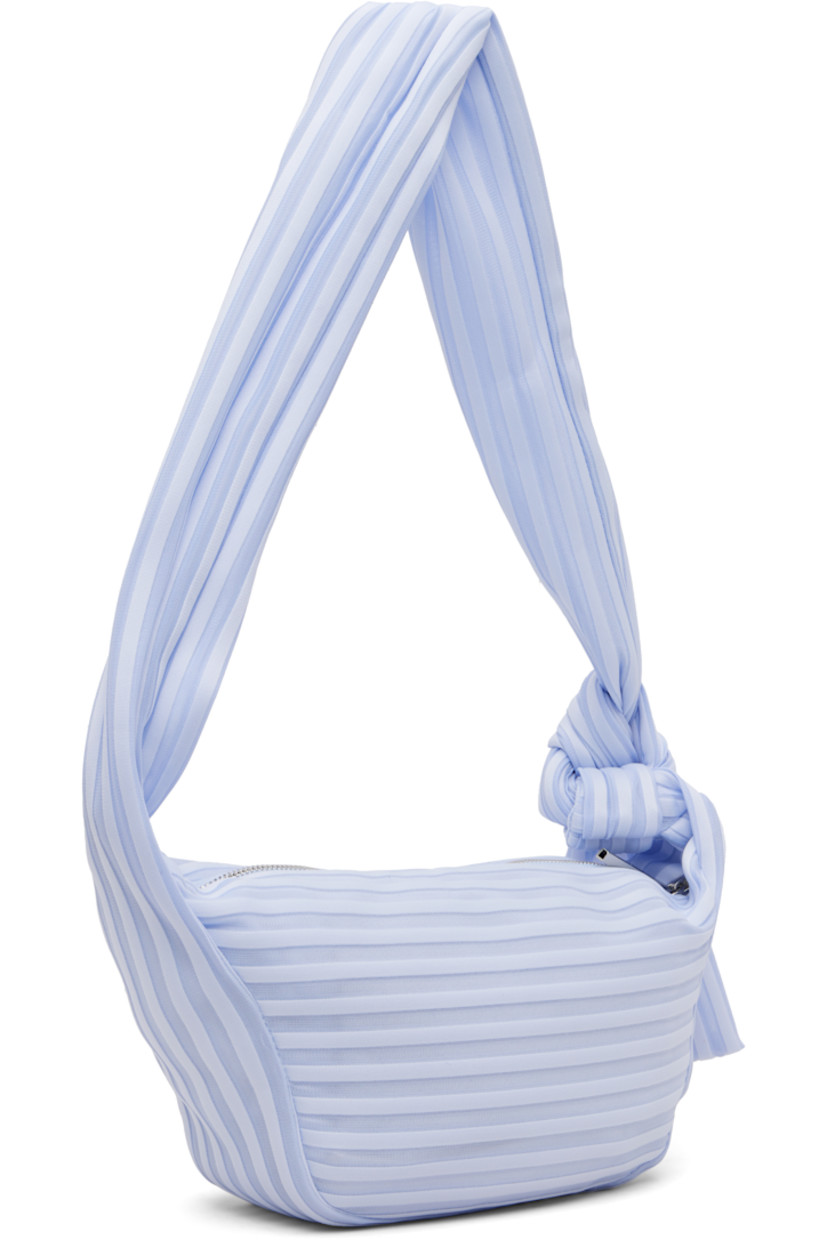 Technical knit shoulder bag.

· Semi-sheer ribbed stripes throughout
· Adjustable self-tie crossbody strap
· Zip closure
· Phone compartment at interior
· Unlined
· H6" x W11" x D3.5"

Supplier color: Nigella Blue