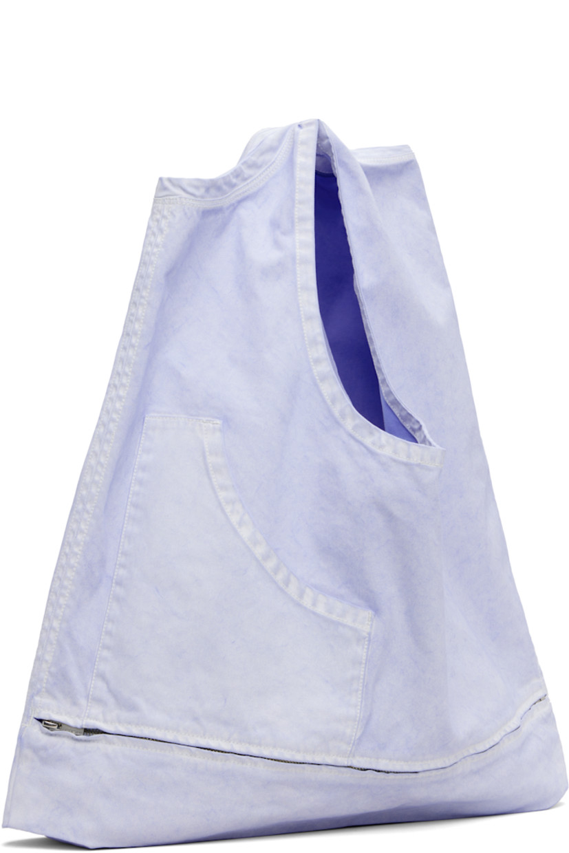 Convertible denim shoulder bag. Converts to sleeveless top with zip fastening at waist.

· Fading throughout 
· Fixed shoulder straps
· Patch pocket at face
· Open throat
· Unlined
· Contrast stitching in white 
· H13.5" x W23" x D3"
· Total height: H20"

Supplier color: Light blue