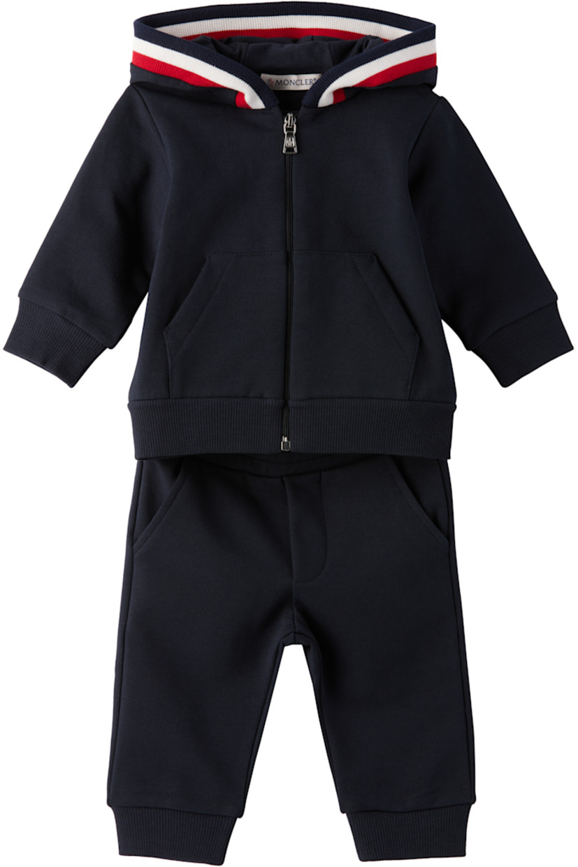 Stretch cotton fleece hoodie. 

· Tricolor rib-knit trim at hood
· Zip closure 
· Patch pockets at waist
· Rib-knit hem and cuffs
· Tricolor logo patch at sleeve

Stretch cotton fleece sweatpants.

· Elasticized waistband
· Two-pocket styling
· Mock fly 
· Rib-knit cuffs
· Logo flag at back waistband 

Supplier color: Navy blue 

Moncler Enfant Size: child's height
1-3M: 21.7" / 55 cm
3-6M: 24.4" / 62 cm
6-9M: 26.7" / 68 cm
9-12M: 29.9" / 76 cm
12-18M: 31.4" / 80 cm 
18-24M: 33.9" / 86 cm
2Y: 36.2" / 92 cm
3Y: 39.4" / 100 cm